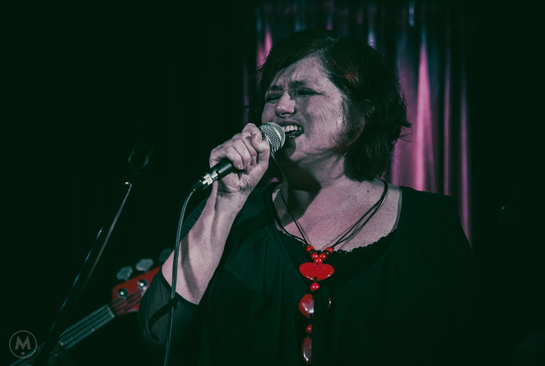 Elise Walsh singing into a microphone during a live performance